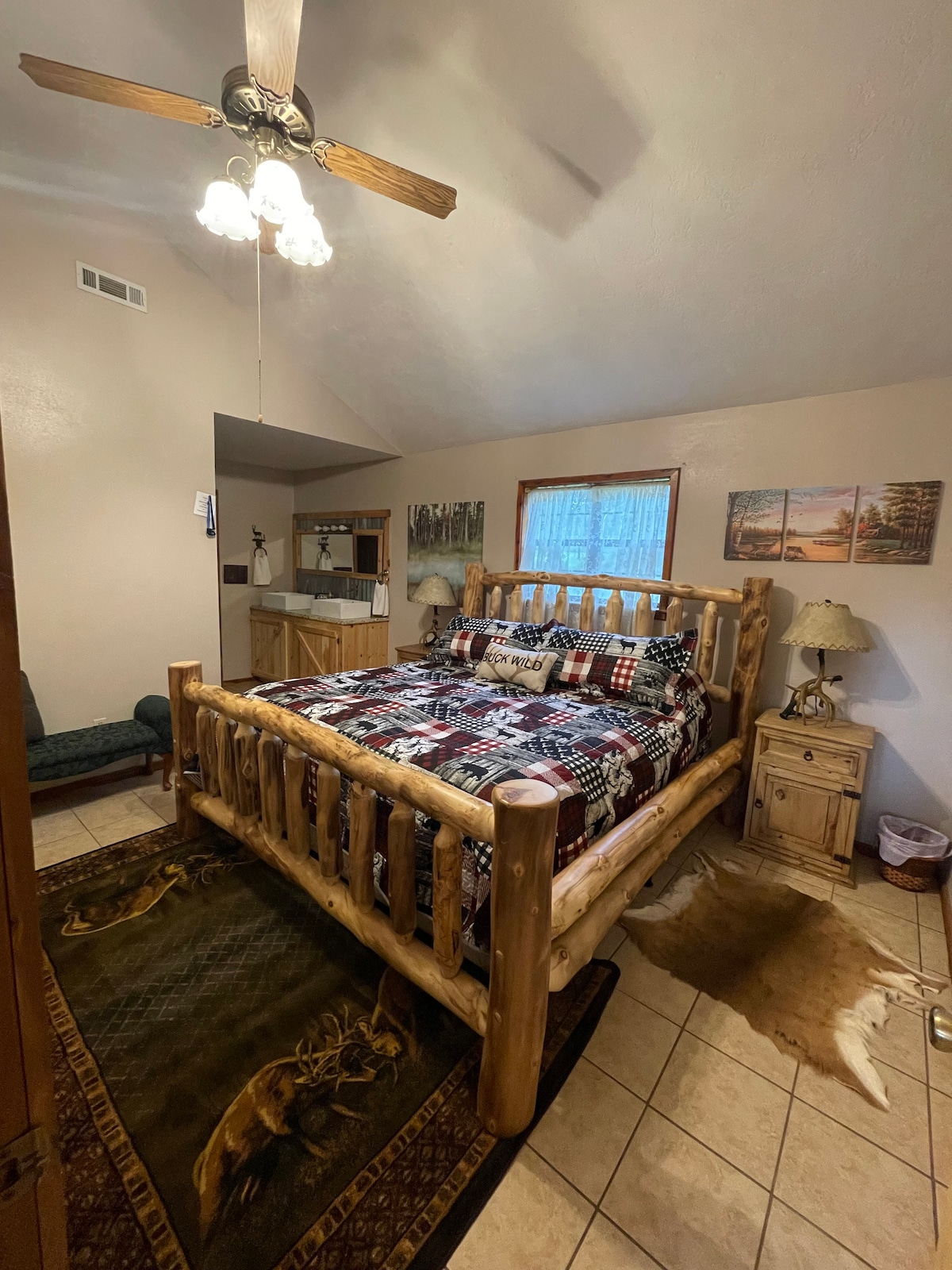 חדר צבאים. חדר שינה ראשי בקומה הראשית עם מיטת קינג סייז, כיורים כפולים וחדר רחצה עם אמבטיה לגינה.