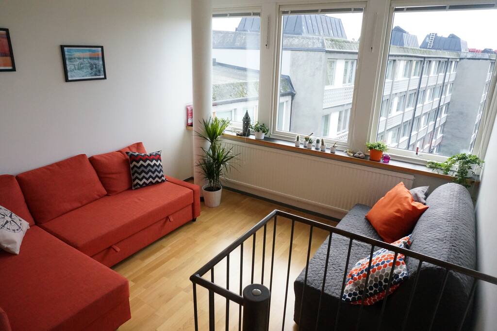 The orange couch is pull out couch that can accommodate two people.