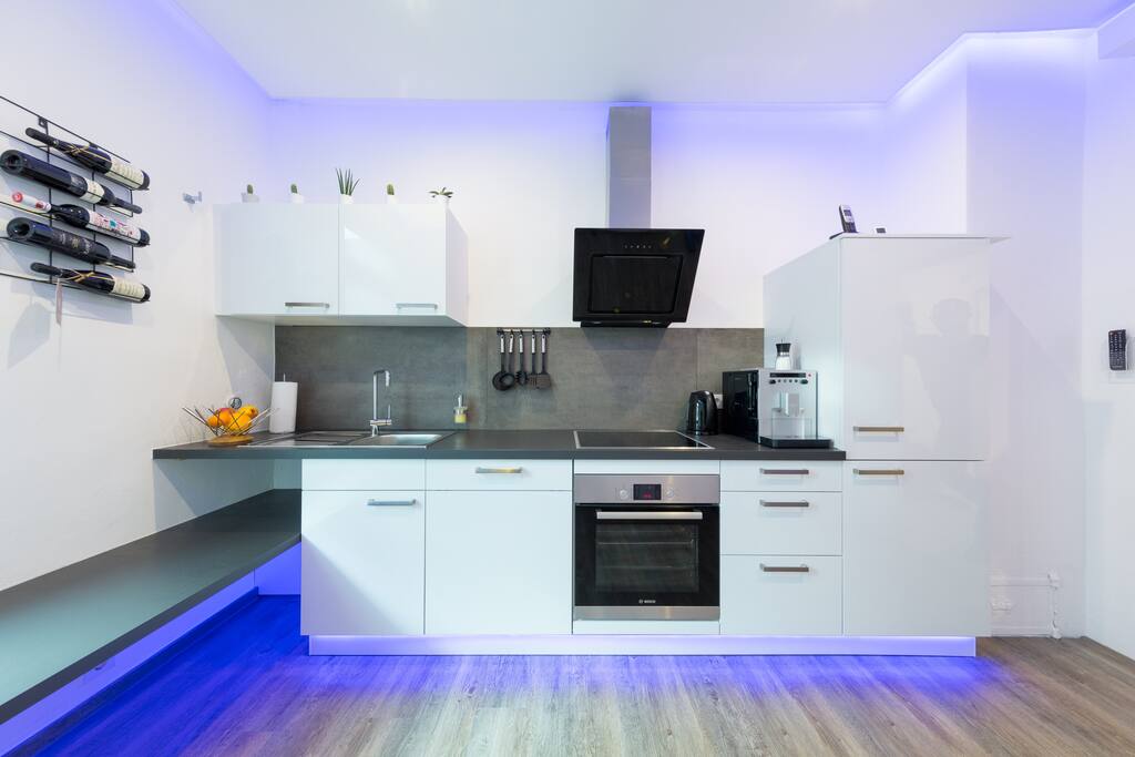 Hochwertige Küche, voll ausgestattet, u.a. mit Geschirrspülmaschine, Kaffeevollautomat, Induktionskochfeld, Backofen, Kühl-/Gefrierschrank, Wasserkocher, LED-TV