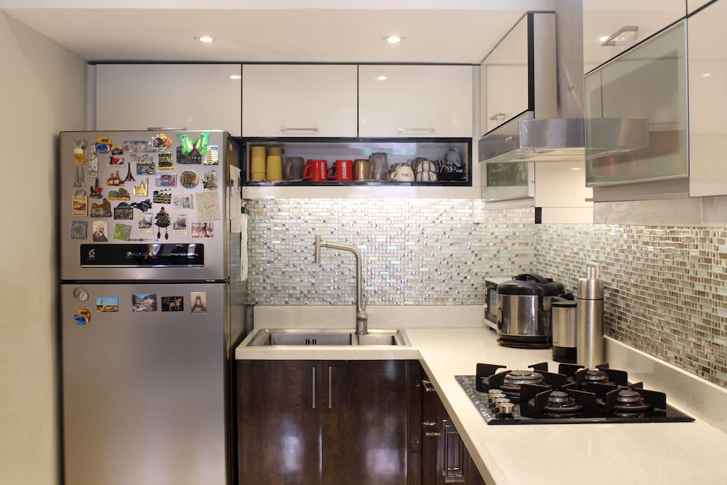 COMMON KITCHEN DOWNSTAIRS | Free use of our kitchen. Just provide your own ingredients when cooking. Utensils and cutleries are provided. Water from the faucet is filtered and drinkable. Ice and cold water are available too in the fridge.