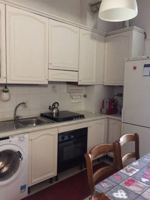 Cucina con lavatrice e frigo