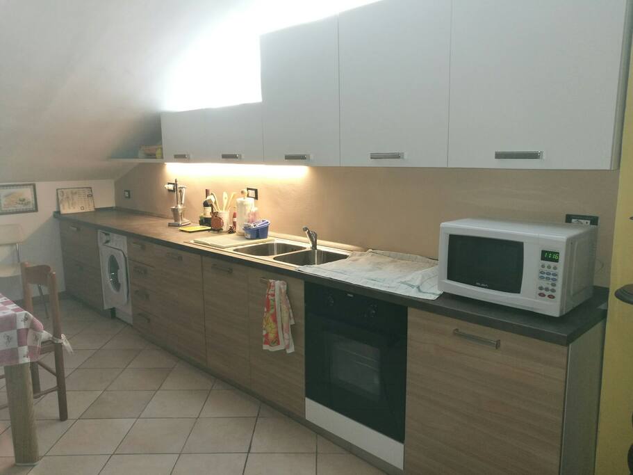 ampia cucina attrezzata con fuochi, forno, lavastoviglie e lavasciugatrice