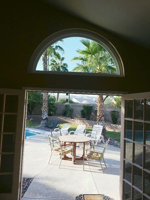 View from master bedroom out on to pool deck and huge back yard