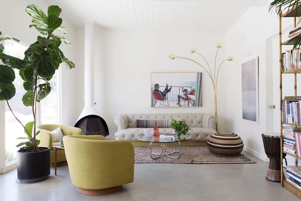 Living Room with gas fireplace and wall of south facing windows framing the pool and backyard