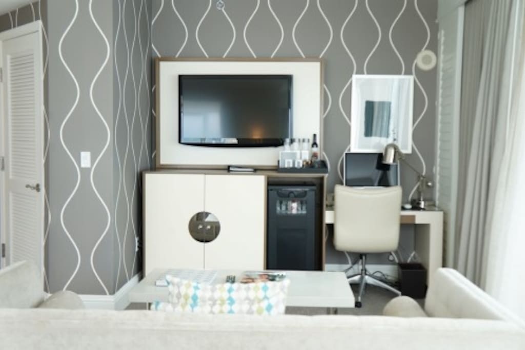 Living room with queen size pull out sofa, plasma TV with premium cable and work desk with Apple desktop