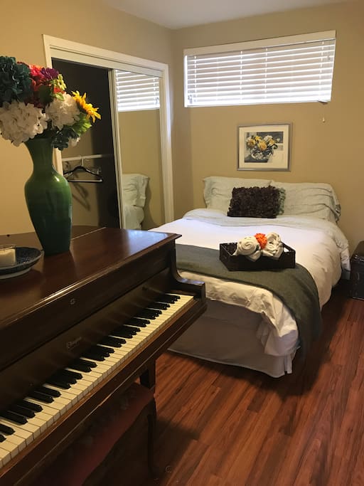 Baby grand piano and a full memory foam bed