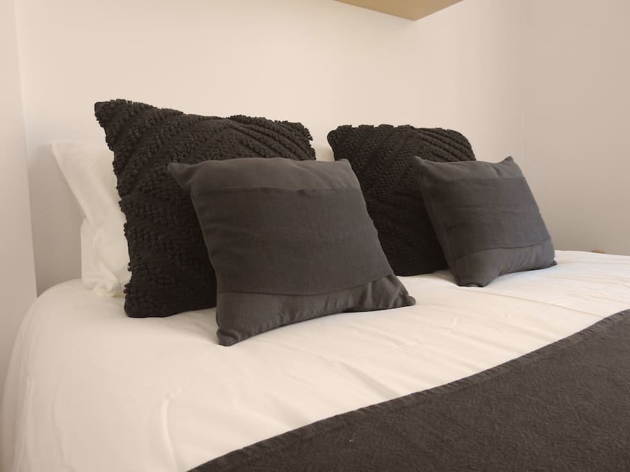 La habitación BLACK tiene dos camas individuales y baño compartido, cuenta con un gran ventanal con vistas al jardín.