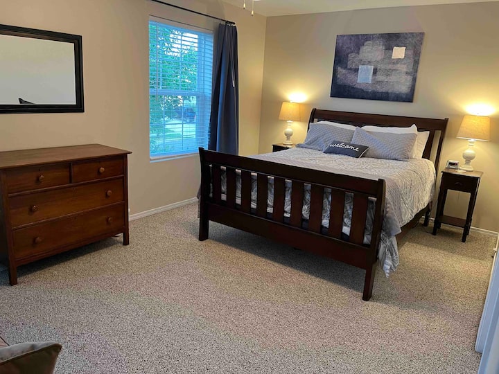 غرفة نوم أمامية في الطابق العلوي بسرير بحجم كوين وكرسي نوم مزدوج