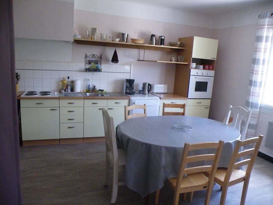 Coin repas et cuisine ouverte dans la pièce à vivre.