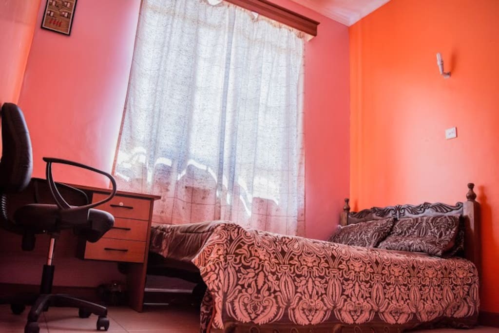 Bedroom No.2 with a double bed, wardrobes, a table and chair.