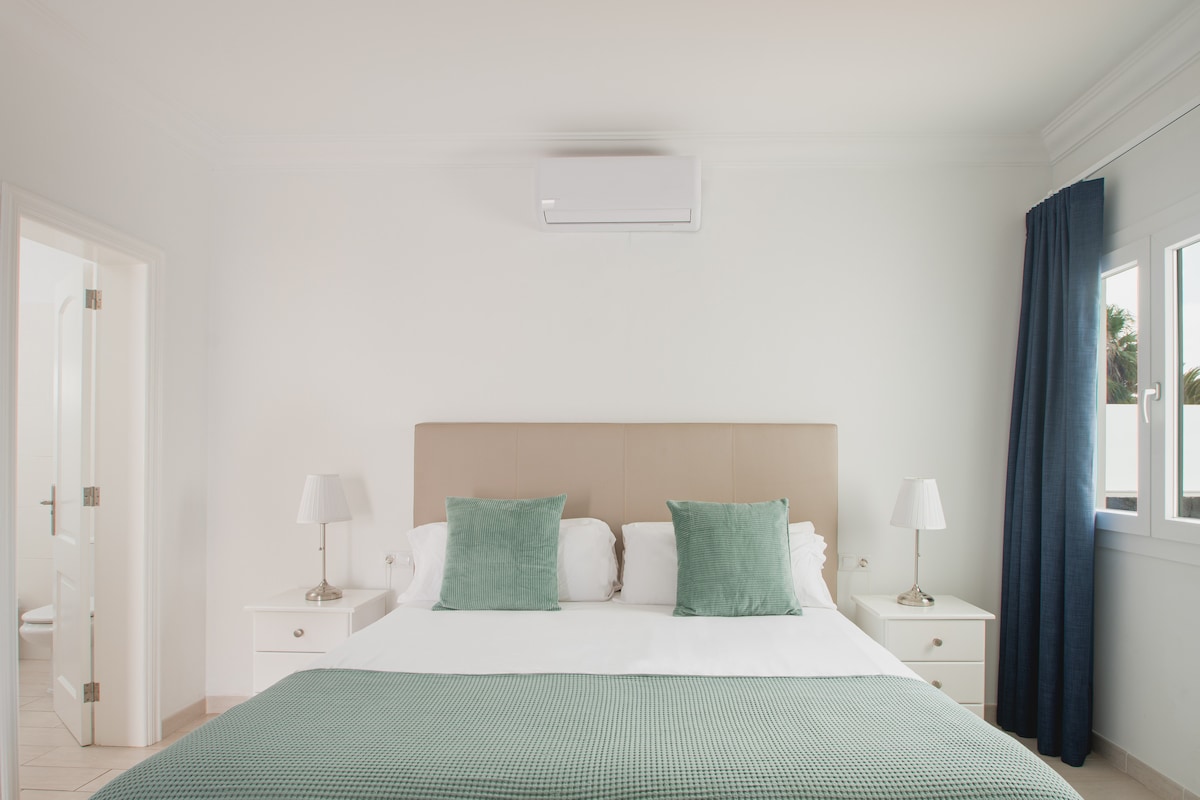 Спална соба со бања и поглед кон градината. Клима уред, сеф и плакар.