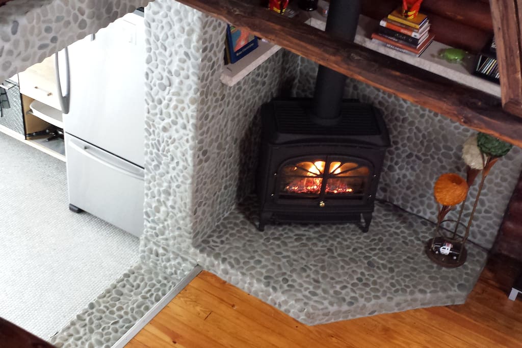 Gas fireplace on stone hearth. Stainless fridge