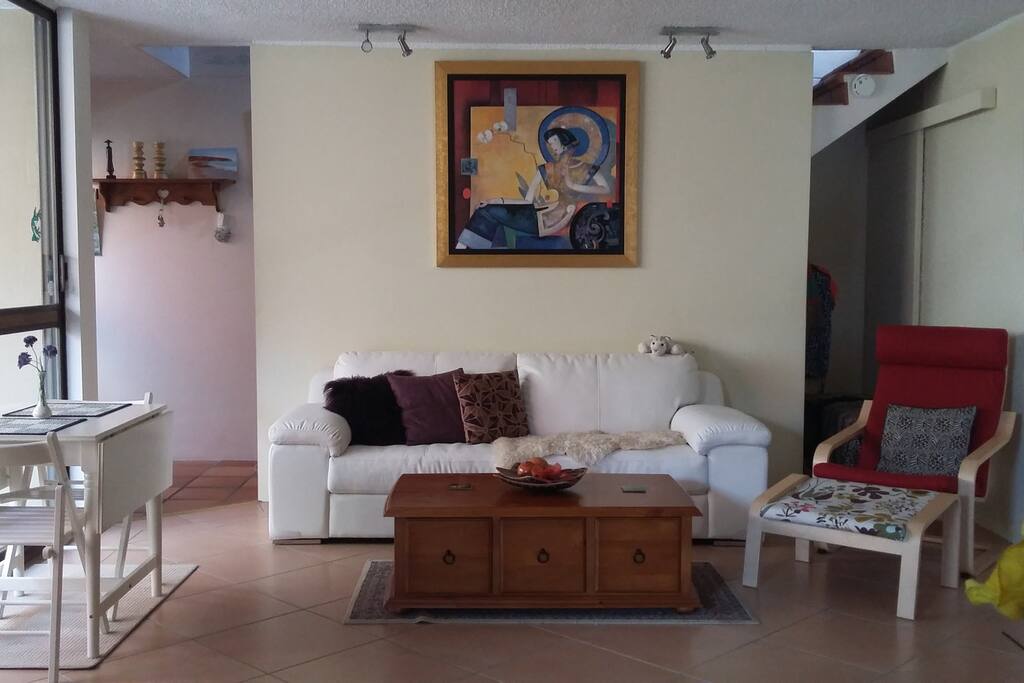Loungeroom with comfy couch, dining table and 55" TV with DVDs