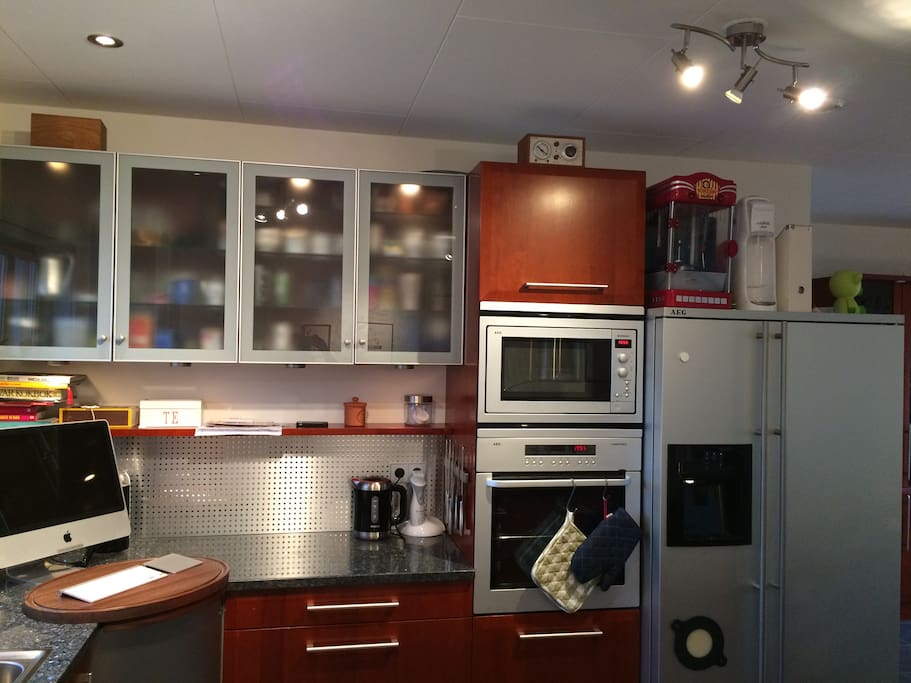 Computer in the kitchen, oven, microwave and fridge & freezer with ice machine.