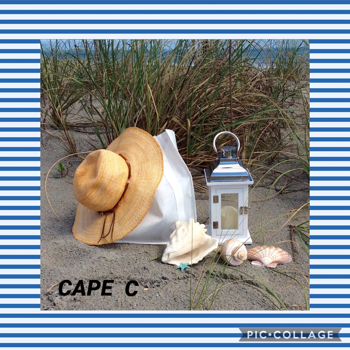 A sun hat rests beside a white bag on sandy terrain, accompanied by a lantern and an assortment of seashells. Beach grass is visible in the background, suggesting a coastal setting.