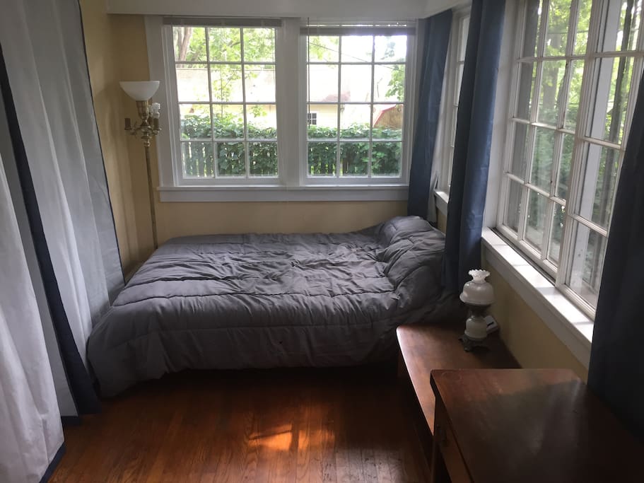 Sunroom has private entrance, bed for two; curtains separating it from living room