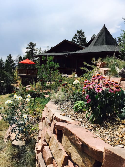 Gardens around the brick patio and deck bloom all summer long.