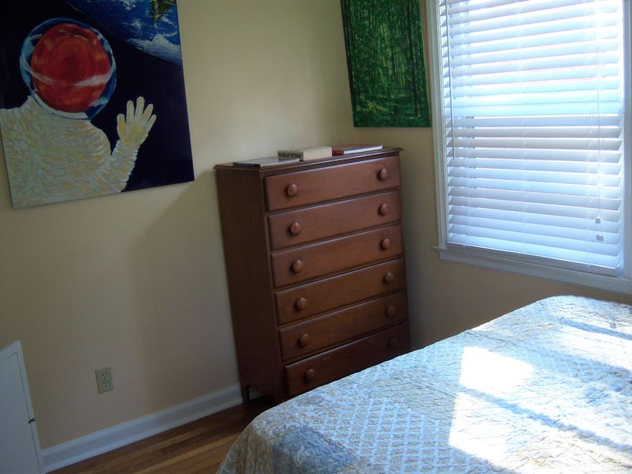 The private bedroom has a queen sized bed and chest of drawers.