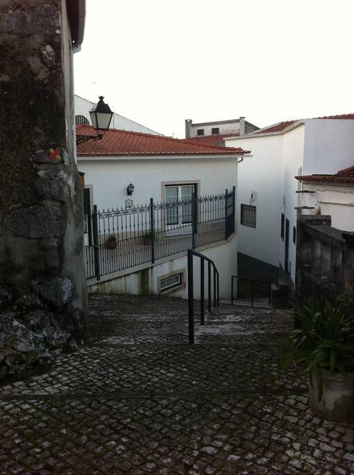 Vista da rua da "Baiuca dos Penedos", localizada bem no centro histórico de Minde. Esta casa rústica tem a particularide de ter mantido os elementos originais, tendo sido integrada nas pedras (penedos) que lhe servem de suporte base.