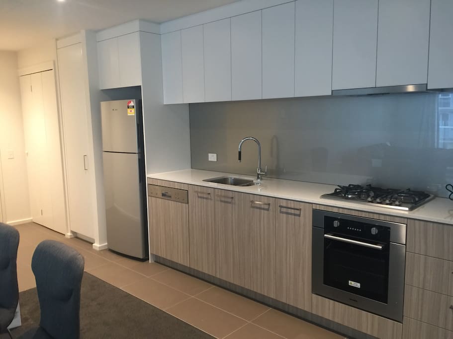 Modern,open kitchen with dish washer,oven and Gas cooking top.
