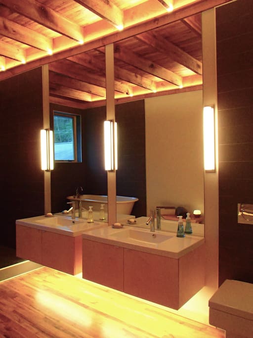 Spacious bathroom with rainforest shower and cast iron tub and two vanities