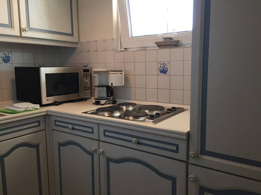 Küche mit 4-Platten-Herd, Backofen-/Mikrowellen Kombi, Kühlschrank mit *** Gefrierfach und reichlich Geschirr/Besteck