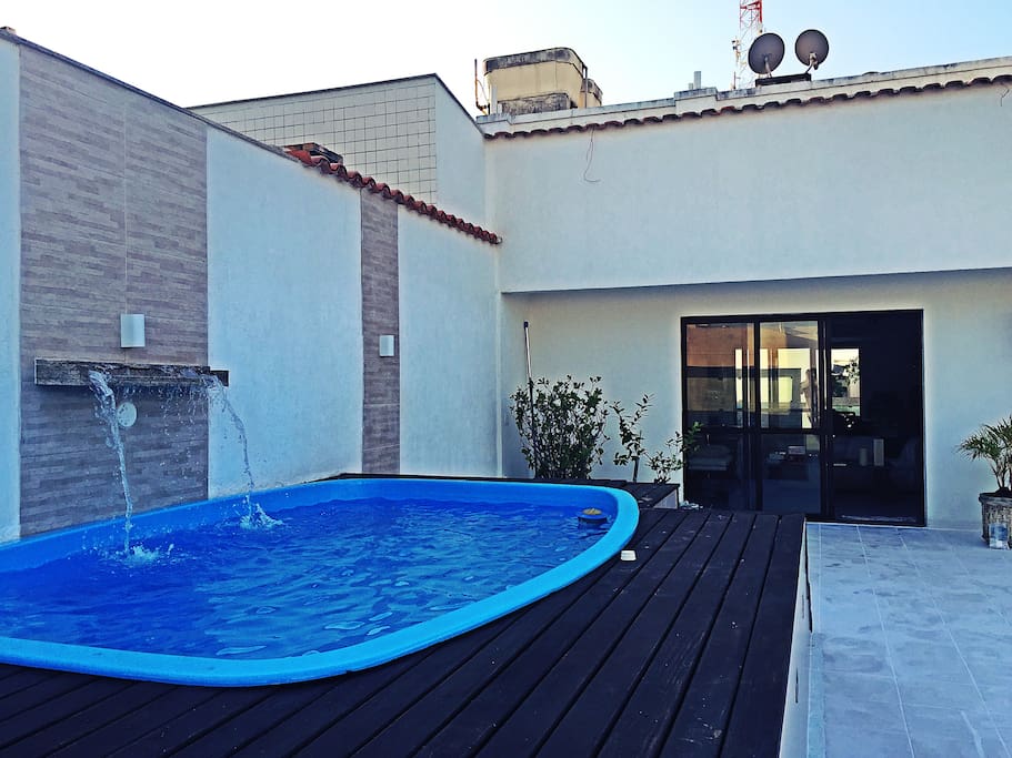 Private pool with waterfall in real wood deck for sunbathing.