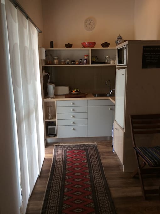 The kitchennette has toaster, coffee machine, fridge, and microwave.