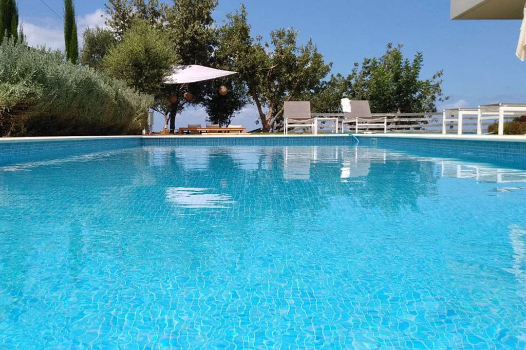40 sq. m ecological swimming pool surrounded by sun beds and umbrellas.