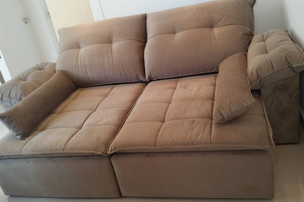 Um sofá enorme retrátil onde podem dormir 2 pessoas tranquilamente