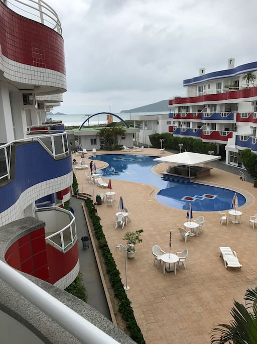 Vista da piscina descoberta com a praia ao fundo.