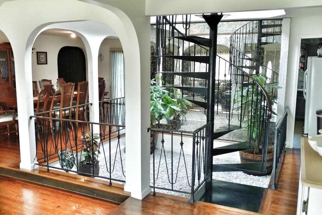 View of indoor garden, spiral staircase from foyer