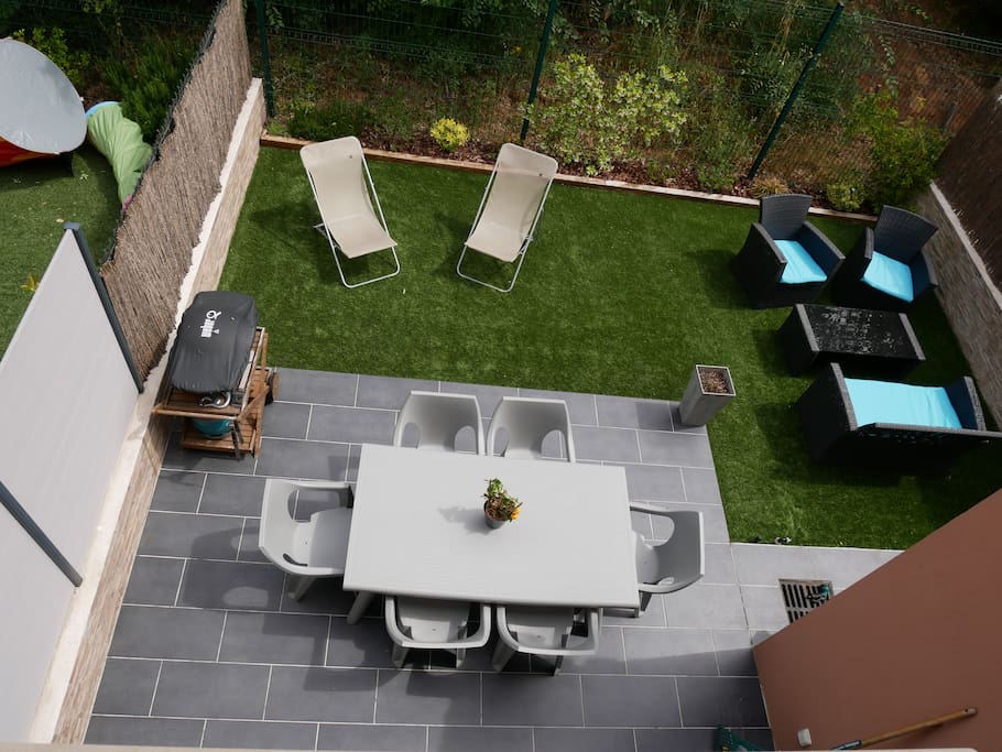 Jardin, terrasse côté nord avec barbecue et salon de jardin.