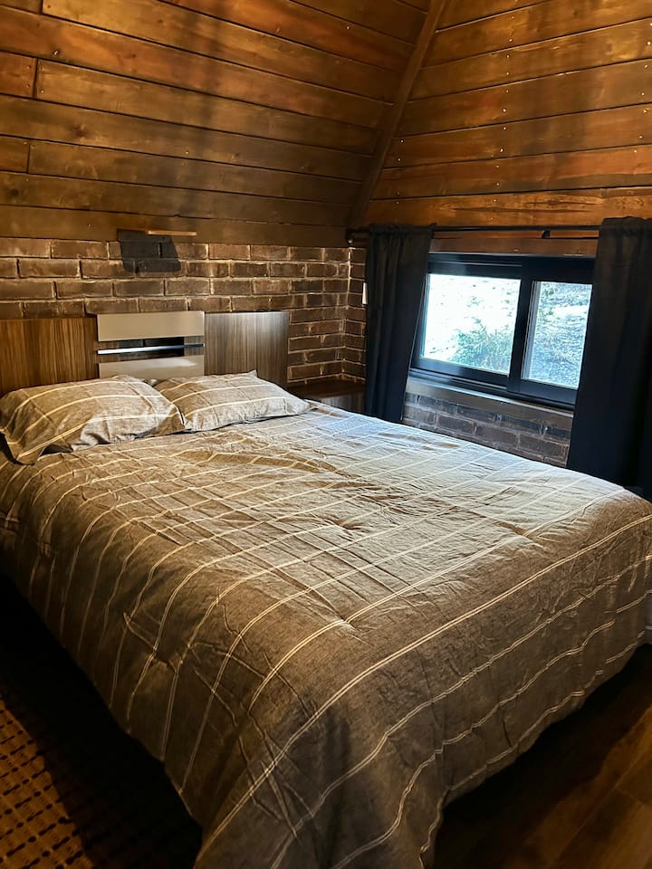 Ცალკე საძინებელი პირველ სართულზე ფანჯრით, ტელევიზორით, კარადათი და გაზის გამათბობლით.