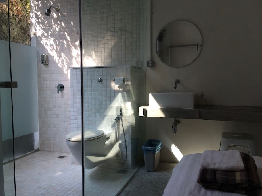 The room is compact. The bathroom has glass walls to maximise the sense of space and access to natural light.