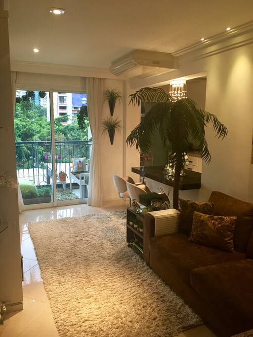 Sala com confortável sofá em L, ar condicionado, TV de alta resolução, giratória, servindo a sala e o dormitório