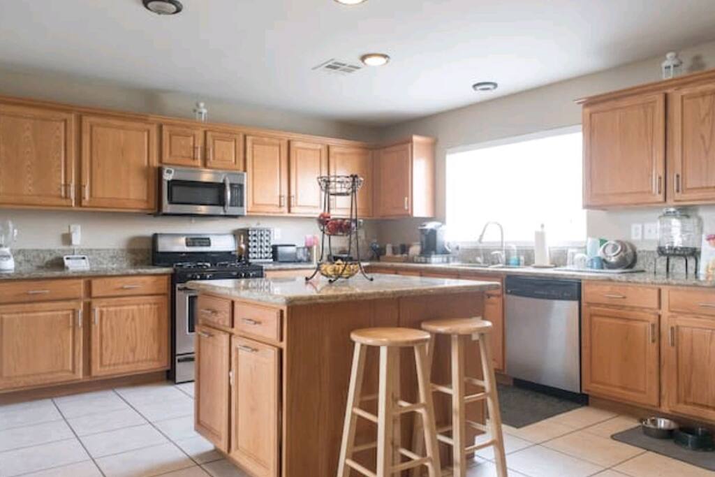 Large granite countertop kitchen with natural light and lots of space to cook.