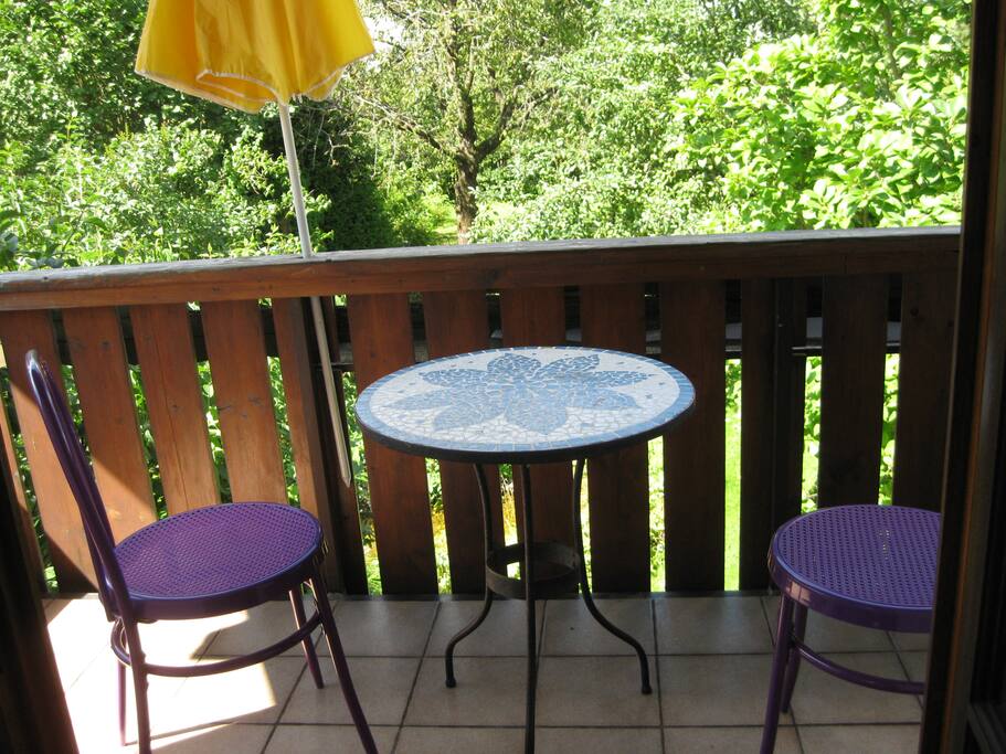 der Balkon zum Garten mit Tisch und 2 Stühlen