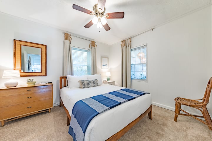 The Lake View Bedroom has a queen size memory foam bed, plush hotel grade bed linens, a dresser, bedside table, lamps, charging stations, and a large closet.