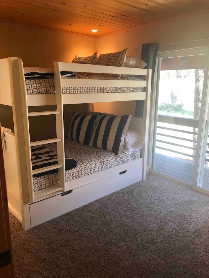 ห้องนอนพร้อมเตียงขนาดใหญ่ 2 เตียงและเตียงแฝดแบบดึงออกมา ห้องนี้ยังมีประตูบานเลื่อนไปยังลานด้านหลังด้านนอก 