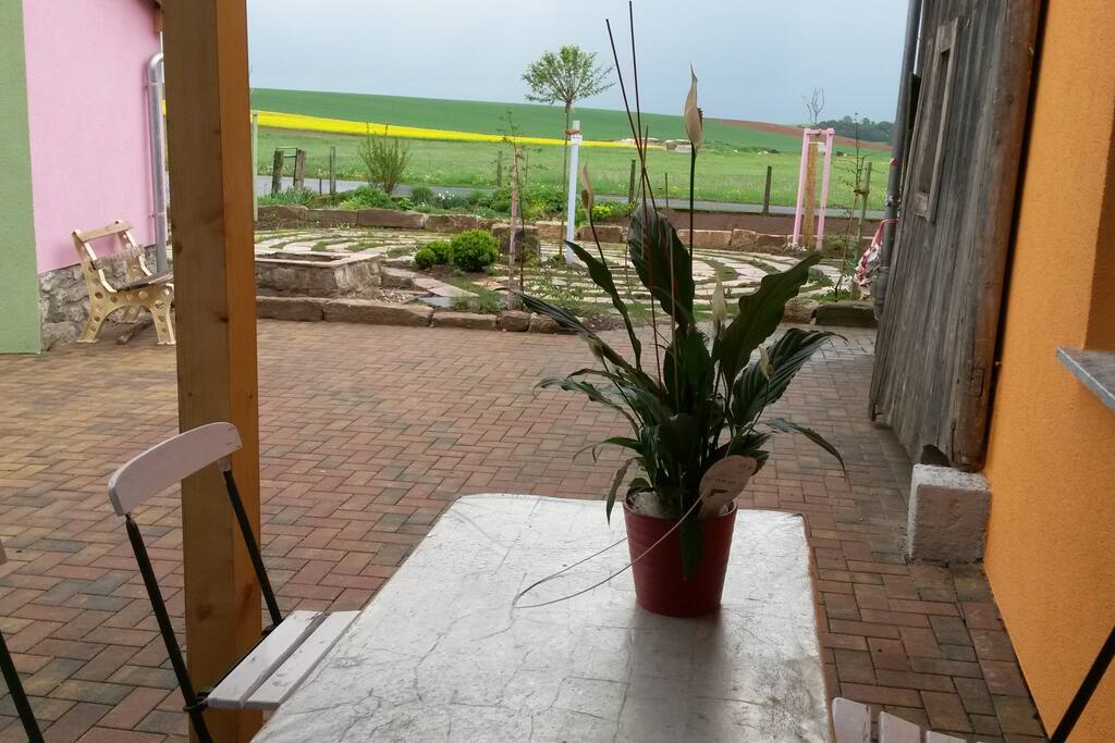 Blick von der Küche auf Hof, Gebets-Labyrinth und Felder dahinter