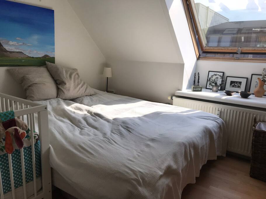 Master bedroom with a crib to the left. The window has a Blackout Blind