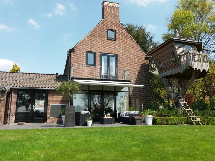 The backyard on the sunny southside and a stunning treehouse with view over the meadows.