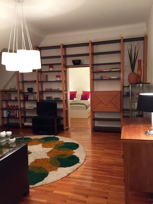 Wohnzimmer mit Regelwand und TV vom Zimmereingang aus