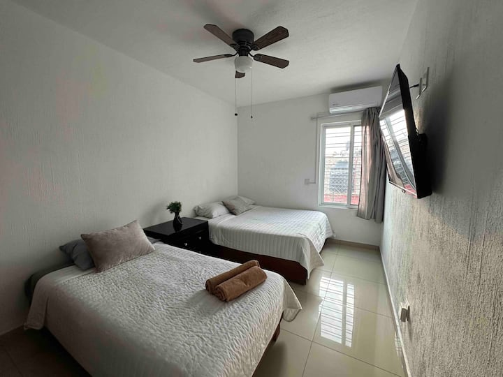 楼上4号房： 1张标准双人床、1张单人床、衣橱、风扇、全功能卫生间和空调 