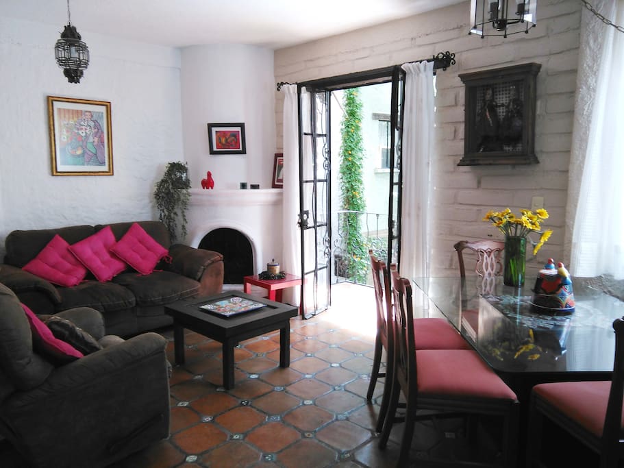 Balcón abierto en la sala con vista al jardín arbolado