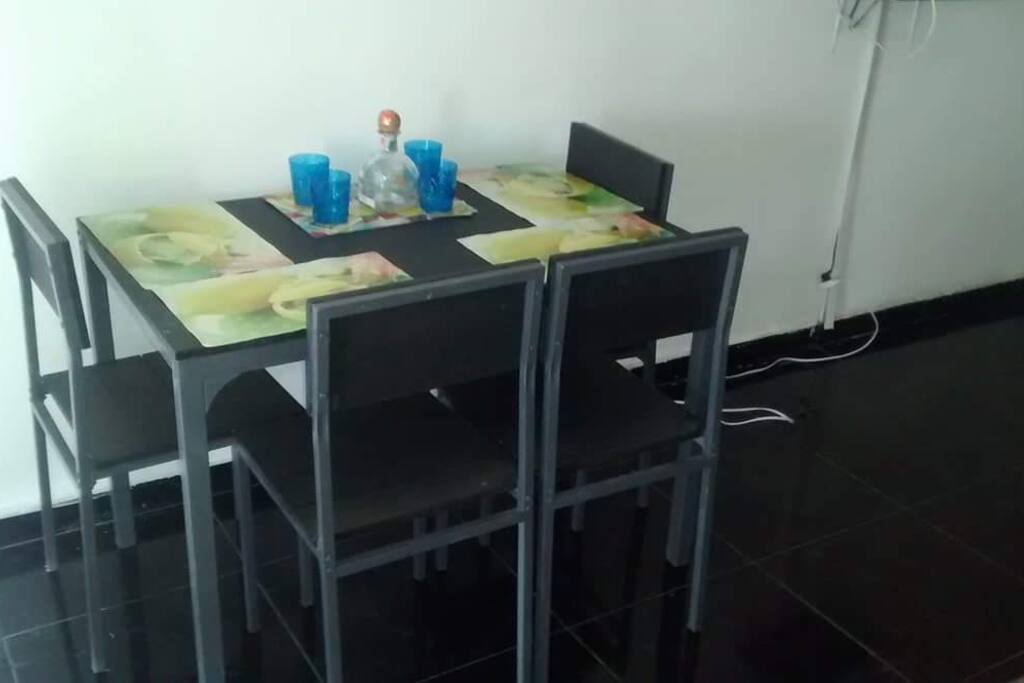 Comedor para cuatro personas frente a un gran ventanal con vista al mar