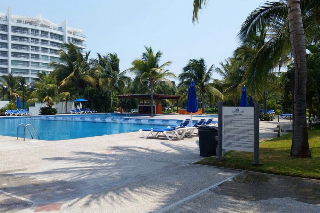 Alberca del Club con su bar dentro de la piscina. Apartment pool with the bar inside the pool.