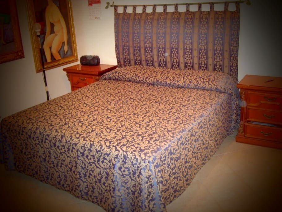 Room one, with a king-sized bed and paintings on the wall
