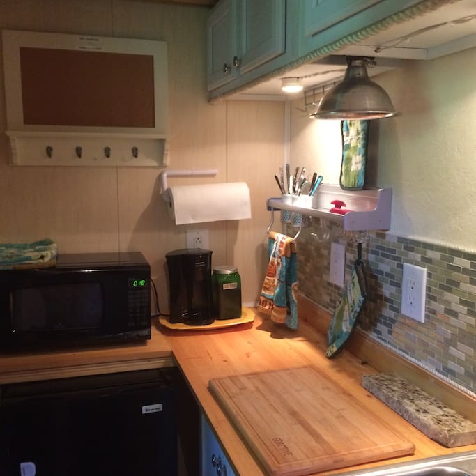 Kitchen area includes microwave fridge and coffee maker.